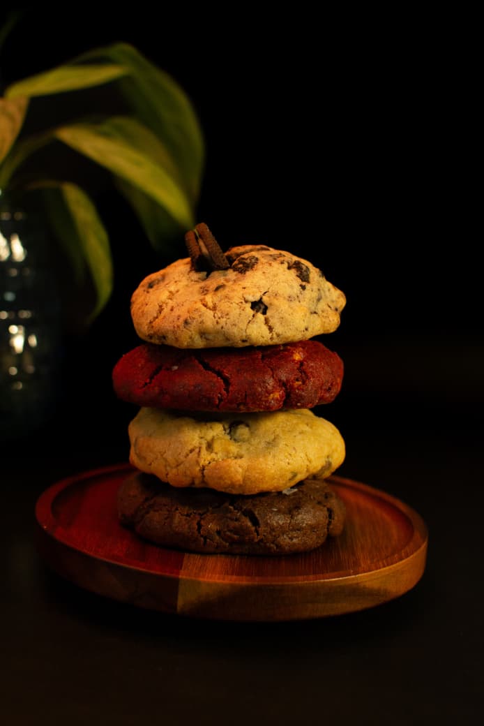 Torre de galletas artesanales Delicazuavía: red velvet, chocolate, clásica y oreo, sobre plato de madera